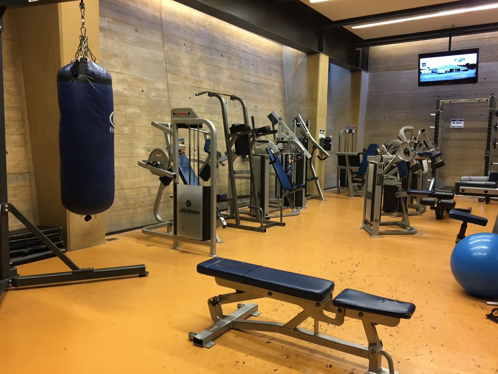 The weight room with a punching bag and many machines