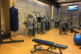 The weight room with a punching bag and many machines